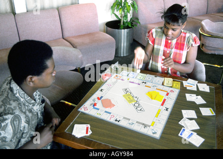 Zwei schwarze ethnische Teens spielen Brettspiel Monopoly an Bord eines Kreuzfahrtschiffes Stockfoto
