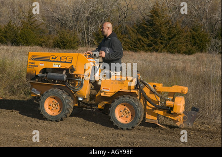 Grabenfräse verwendet, um Rohr für unterirdische Bewässerungssystem ziehen Stockfoto