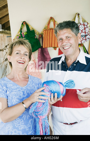 Reife Frau hält ein Bündel von synthetischen Fäden mit einem älteren Mann neben ihr Stand Stockfoto