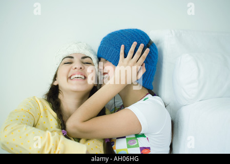 Zwei junge Freundinnen lachen hören Stockfoto