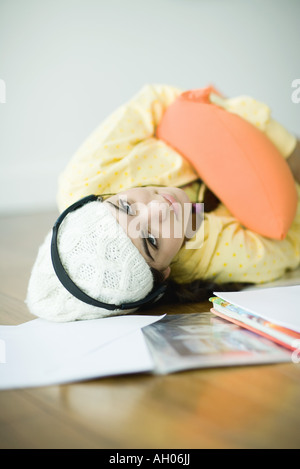 Junge Frau auf Boden hören, Kopfhörer, Hausaufgaben zu vernachlässigen Stockfoto