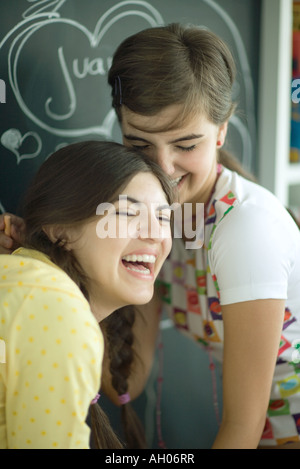 Junge Freundinnen Namen im Herzen an Tafel schreiben, lachen Stockfoto