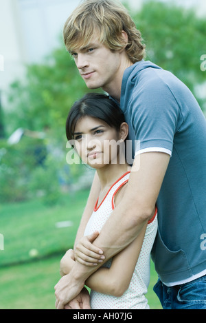 Junges Paar, Mann mit Arme um Frau, Frau, die ihn gelehnt Stockfoto