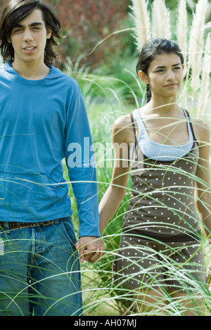 Junge Paare, die durch lange Gräser der Ziergarten Stockfoto