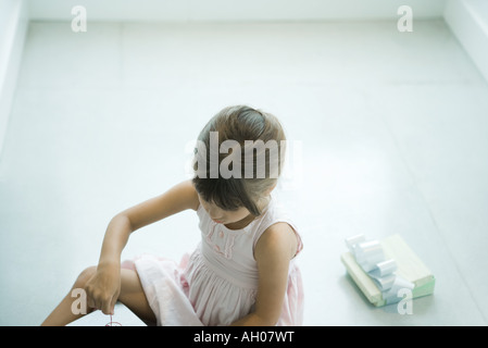 Mädchen sitzen auf Boden, Eröffnung präsentiert Stockfoto