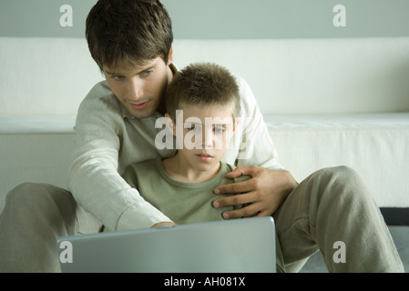 Junge und Laptop zusammen mit Vater Stockfoto