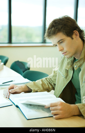 Junger Mann in der Universitätsbibliothek zu studieren Stockfoto