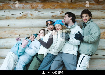 Gruppe in Winterkleidung zurückfallen auf jede andere, Dreiviertel Länge, vor Blockwand, Porträt Stockfoto