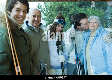 Gruppe von Skifahrern, junger Mann küssen senior Frau am Check, Porträt Stockfoto
