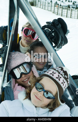 Gruppe von Skifahrern posiert unter Skiern im Schnee, Porträt Stockfoto