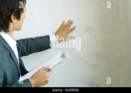 Mann im Anzug mit Zwischenablage, Wand Stockfoto