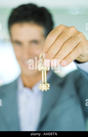 Immobilienmakler hält Schlüssel, Fokus auf Tasten im Vordergrund, Nahaufnahme Stockfoto