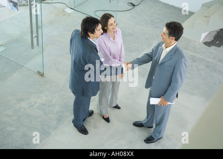 Junges Paar Händeschütteln mit Immobilienmakler, erhöhte Ansicht Stockfoto