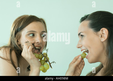 Zwei junge Freunde essen Trauben, Lächeln Stockfoto