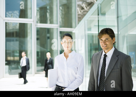 Zwei junge Geschäftspartnern lächelnd in die Kamera, Hüfte aufwärts, Porträt Stockfoto