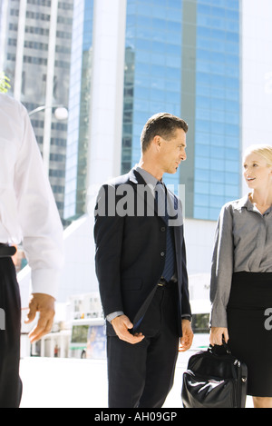 Zwei Geschäftspartner auf Bürgersteig stehen, sahen einander, diskutieren Stockfoto