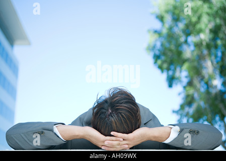 Geschäftsmann auf Rücken, Hände hinter Kopf, Rückansicht Stockfoto