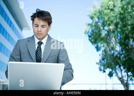 Jungunternehmer im Freien, mit Laptop-Computer, auf der Suche nach unten Stockfoto