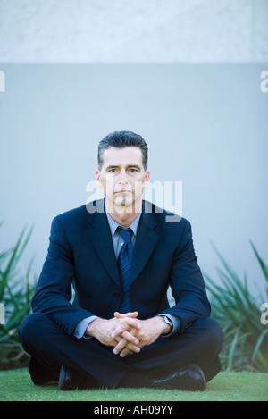 Geschäftsmann, sitzen auf Boden, Blick in die Kamera, in voller Länge portrait Stockfoto