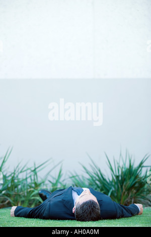 Geschäftsmann am Boden im Freien liegenden vollen Anzug Stockfoto