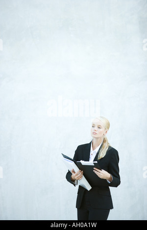 Junge Geschäftsfrau, stehen, Datei, wegschauen Stockfoto