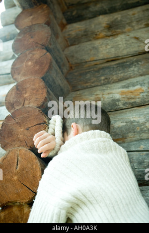 Junge in der Ecke stehen, ruhen Kopf auf Arme, Rückansicht Stockfoto