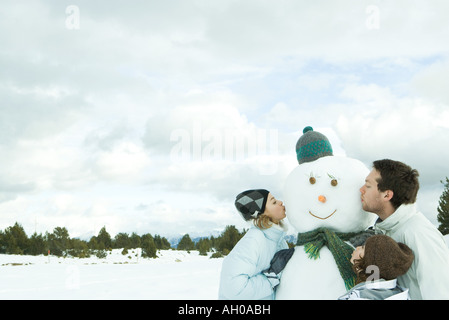 Drei junge Freunde küssen, Schneemann, Kopf und Schultern Stockfoto