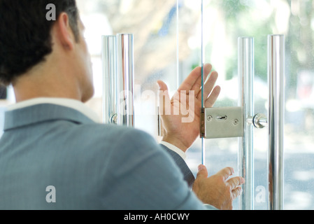 Mann, die Inspektion Sperre für Glastür Stockfoto