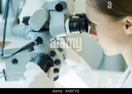 Junge Frau im wissenschaftlichen Labor arbeiten mit Mikroskop Stockfoto