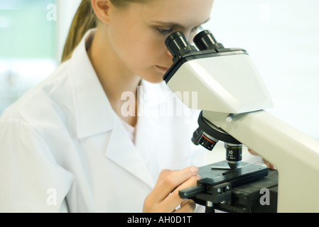 Junge Wissenschaftlerin mit Mikroskop Stockfoto