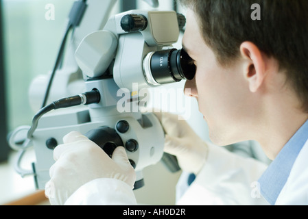 Junge männliche Wissenschaftler mit Mikroskop Stockfoto