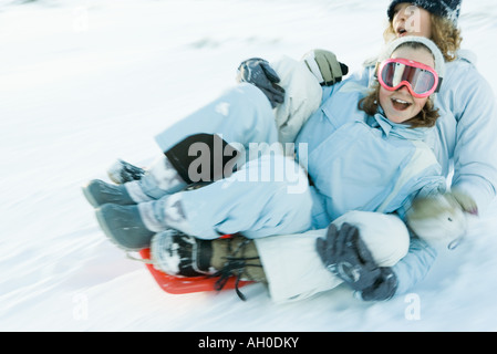 Zwei junge Freunde fahren Schlitten zusammen, verschwommen Bewegung Stockfoto