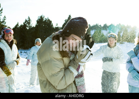 Junge Freunde werfen Schneebälle, lächelnd, verschwommen Bewegung Stockfoto