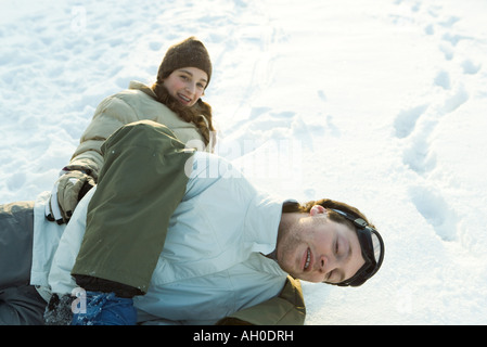 Bruder und Schwester spielen kämpfen im Schnee, liegend in den Boden, in die Kamera Lächeln Stockfoto