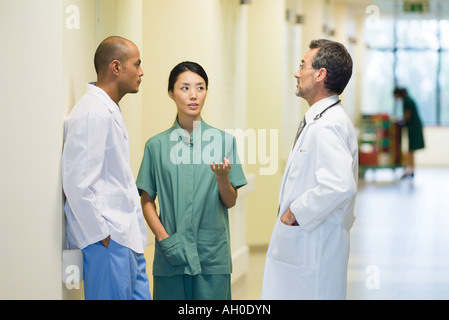 Medizinisches Personal im Flur stehen, diskutieren, sahen einander Stockfoto