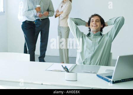 Geschäftsmann, sitzen im Büro, lehnt sich zurück, Lächeln Stockfoto