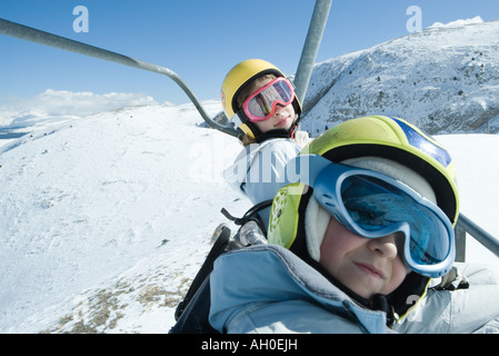 Zwei junge Freunde am Skilift, beide tragen Skibrillen, einen Blick in die Kamera Stockfoto