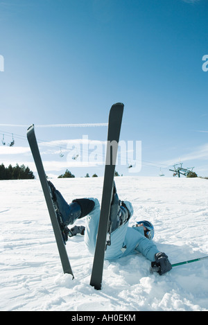 Junge Skifahrer am Rücken auf dem Boden, Beine in der Luft liegen Stockfoto