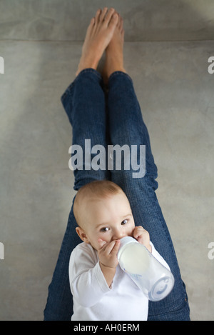 Babysitter auf Frau Schoß, trinken aus Baby-Flasche Stockfoto
