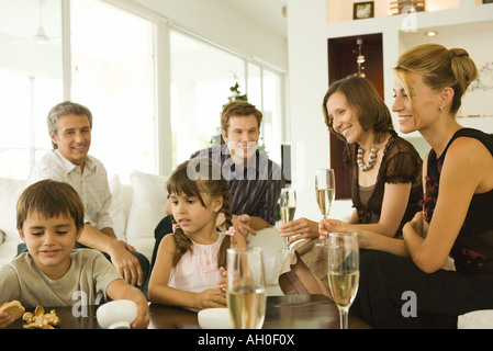 Vier Erwachsene Champagner trinken, beobachten Kinder, Lächeln Stockfoto