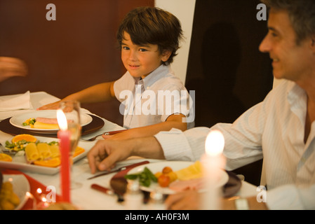 Mann und der Junge sitzt am Esstisch, Lächeln Stockfoto