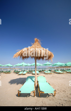 KRETA, GRIECHENLAND. Sonnenliegen und Stroh Sonnenschirm am Strand von Elafonisi im Südwesten der Insel Stockfoto