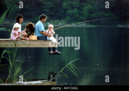 Vater und Mutter mit zwei Kindern und Hund der Familie am See angeln Picknick in Schweden Stockfoto