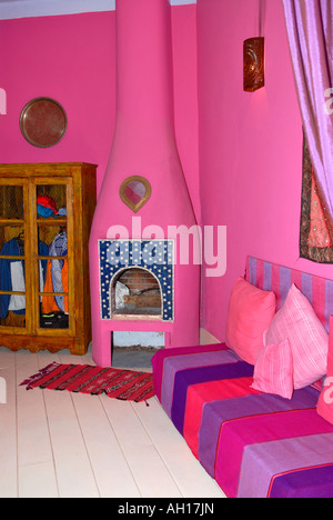 Marokko, Essaouira, Riad El Madina Hippie Hotel, typisch afrikanischen leuchtend rosa, lila, lila & lila sitzen Zimmer & Schlafzimmer Stockfoto