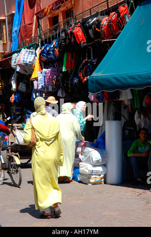 Marokko, Marrakesch, Jemaa El Fna oder Djemaa El-Fna Souk typisch afrikanischen Markt Straßenszene mit Dame zu Fuß in gelb hijab Stockfoto