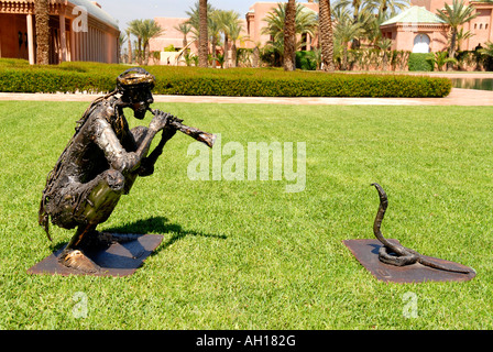 Marokko, Marrakesch, das exklusive Hotel Amanjena, moderne zeitgenössische Statuen der Schlangenbeschwörer & Schlange draußen auf Rasen Stockfoto