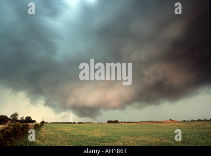 Ein Blitzschlag aus einer dramatischen Entwicklung Gewitter in Texas über Ackerland Stockfoto