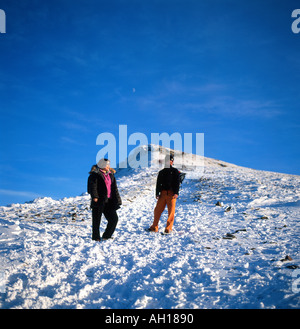 Menschen Mann und Frau in Winterkleidung stehen auf schneebedecktem Schnee auf Pen y Fan Brecon Beacons National Park Powys Wales Großbritannien KATHY DEWITT Stockfoto