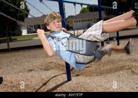 Schüler spielen auf einer Schaukel auf einem Schulhof Stockfoto