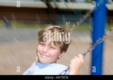 Schülerin, spielt auf einer Schaukel während Aussparung in der Schule Stockfoto